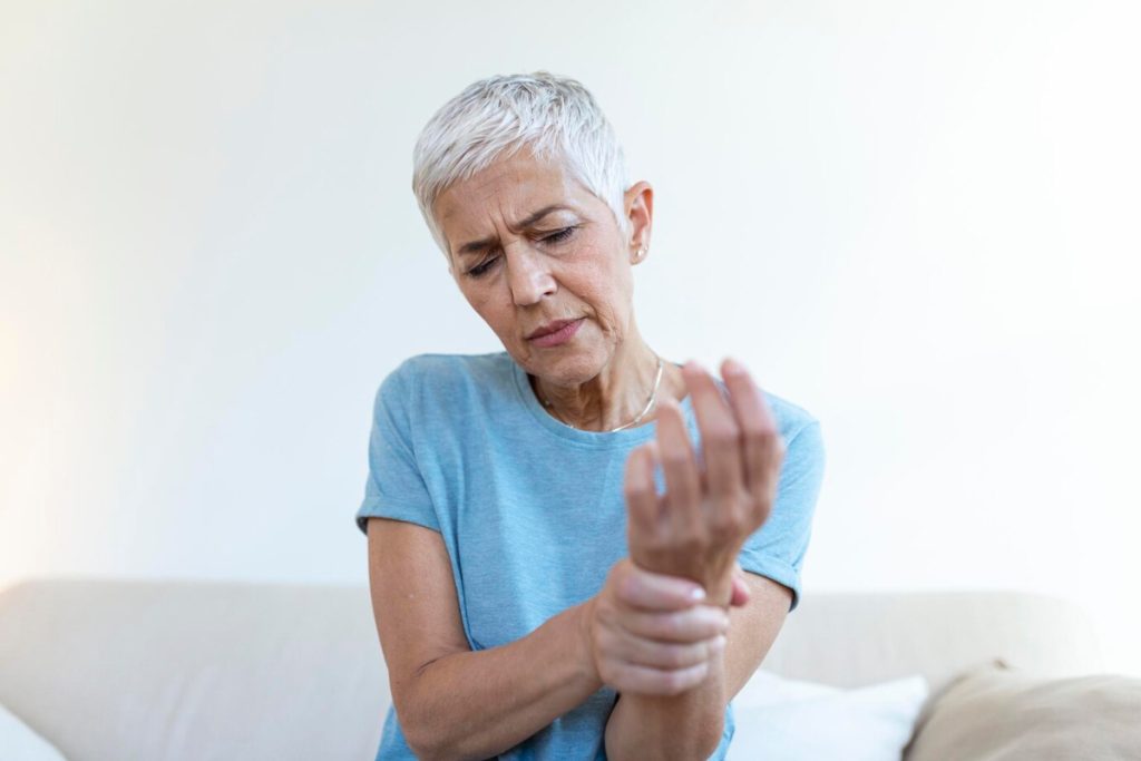 Adulto mayor con dolor en las articulaciones de la mano.